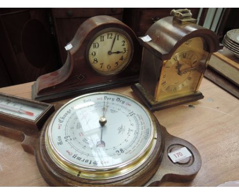 An aneroid barometer and thermometer in oak frame and two mantel clocks