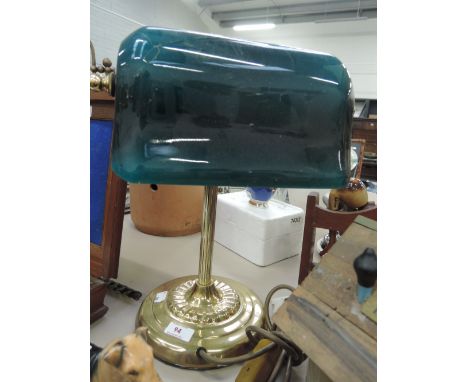 A brass desk lamp with green glass shade
