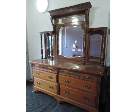 A late Victorian mahogany full height sideboard having triple mirror and pillar superstructure over drawers on bracket plinth