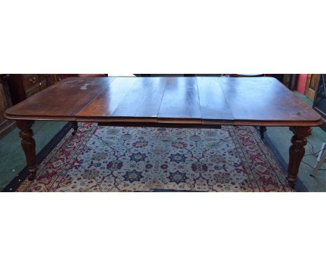 A 19th century mahogany extending dining table, associated leaves, turned tulip carved legs, ceramic casters, extends to 255c