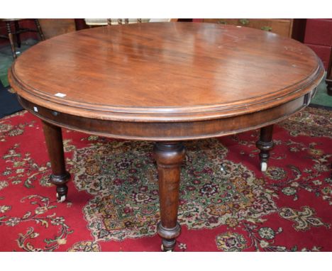 A 19th century mahogany circular extending dining table, moulded top, turned tapered legs, ceramic casters, void of leaves, 1