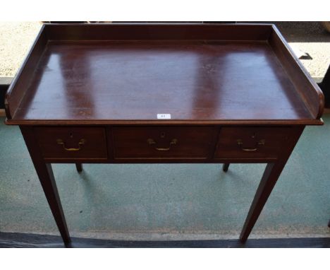 A 19th century mahogany side table, moulded top with three quarter gallery above three short drawers, brass swing handles, ta