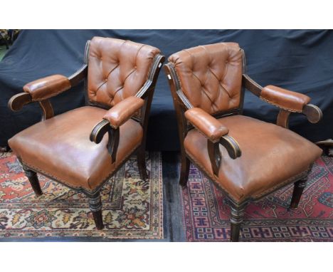 A pair of Victorian oak button back library chairs, reeded scroll arms, turned and reeded forelegs, stuffed over leather upho