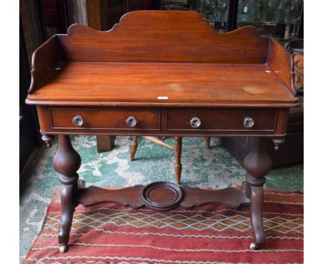 A Victorian mahogany washstand, shaped three quarter gallery above a deep frieze with a pair of short drawers and turned unde