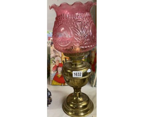 An oil lamp with ruby glass shade (missing chimney)