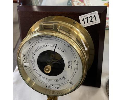 A wood wall plaque mounted brass barometer