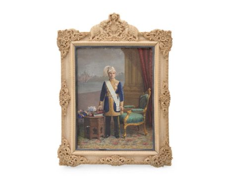 ϒ A full length portrait colour painted photograph of an unknown Indian ruler, circa 1910, in an interior with furniture and 