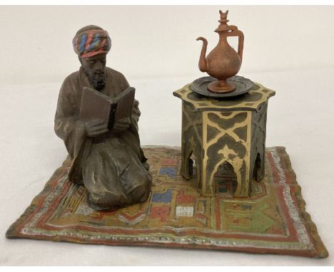 After Bergman - a cold painted Arabian style inkwell. An Arabian gentleman knelt reading on a colourful carpet beside an inkw