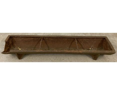 A vintage small cast iron feeding trough with divider bars and fixed feet. Damage to one corner. Approx. 89.5cm long.