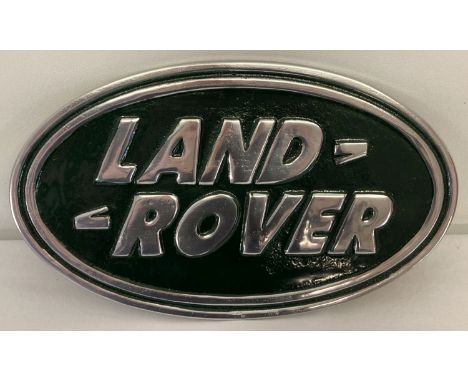 An oval shaped, painted aluminium, Land Rover plaque with wall hanging hook to reverse.  Approx. 18cm x 30cm.