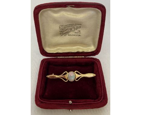 A gold Art Nouveau style bar brooch set with a central opal, tests as 9ct gold. With a vintage red velvet box for Jeweller De
