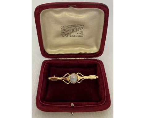 A gold Art Nouveau style bar brooch set with a central opal, tests as 9ct gold. With a vintage red velvet box for Jeweller De