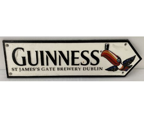A painted cast iron Guinness wall plaque in the shape of an arrow sign. For St James's Gate Brewery in Dublin, with toucan de