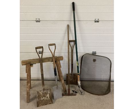 A collection of garden tools together with a metal fireguard and a wooden trestle. Tools include long handled loppers and sho