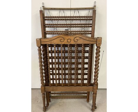 A vintage dark wood cot with barley twist posts and bobbin style spindles.  