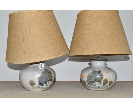A PAIR OF GREYSHOTT CERAMIC LAMPS WITH SHADES to include two matching table lamps with painted tree scenes approximately heig