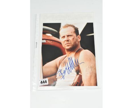 A SIGNED 10 X 8 PRODUCTION STILL OF BRUCE WILLIS IN DIE HARD, portrait orientation, signed in blue marker, accompanied by a H