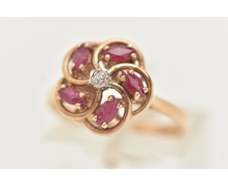 A 9CT GOLD RUBY AND DIAMOND RING, designed as a central brilliant cut diamond, surrounded by marquise shape diamonds set at a