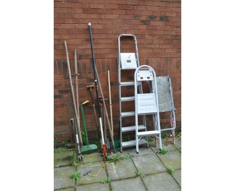 A COLLECTION OF GARDENING TOOLS AND STEPS including a platform step ladder, an aluminium step ladder, forks, hoes, a tree lop