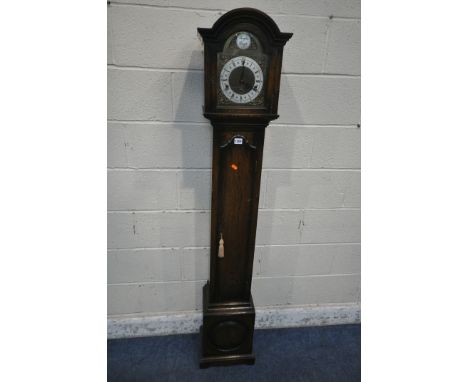A 20TH CENTURY OAK CASE TEMPUS FUGIT CLOCK, the arched hood with a glass door, that's enclosing a brass and silvered 6.5 inch