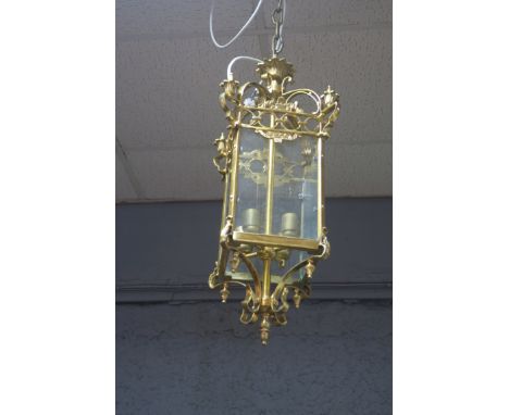 A GEORGIAN STYLE BRASS FRAMED FOUR LIGHT HALL LANTERN, the rectangular bevelled glazed panels headed by an openwork frieze, d