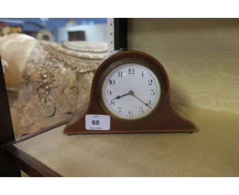 AN EARLY 20th CENTURY MAHOGANY AND MARQUETRY INLAID MANTLE CLOCK of domed outline with white enamel dial and brass bezel 