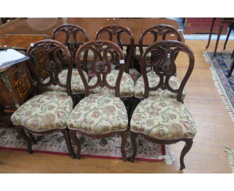 A SET OF SIX VICTORIAN MAHOGANY SPOON BACK DINING ROOM CHAIRS, the open backs centred by a stylised scrolled splat with folia