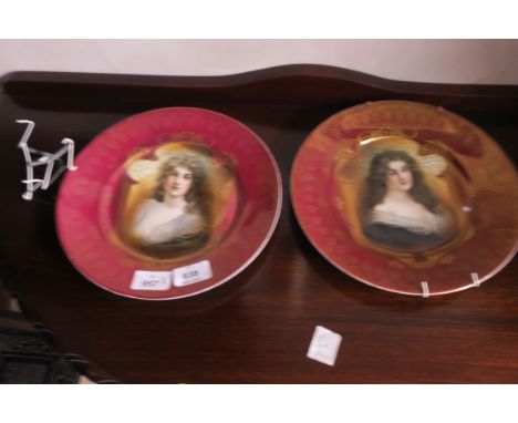 A PAIR OF ORIENTAL PORCELAIN PLATES, each with a puce and gilt ground, with portrait panels, 25cms diameter.