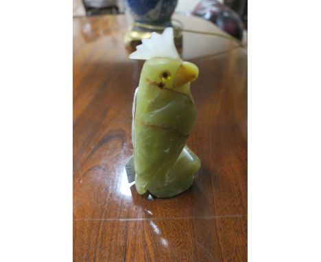 A CARVED JADE FIGURE OF A PARROT, on an oval base.