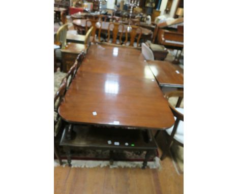 A REGENCY STYLE  MAHOGANY DINING ROOM TABLE, the rectangular top with reeded rim and round corners raised on twin pillared tu