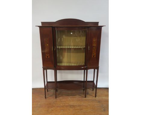 AN EDWARDIAN MAHOGANY INLAID DISPLAY CABINET, the raised back above the breakfront bowed top with a single glazed cupboard do