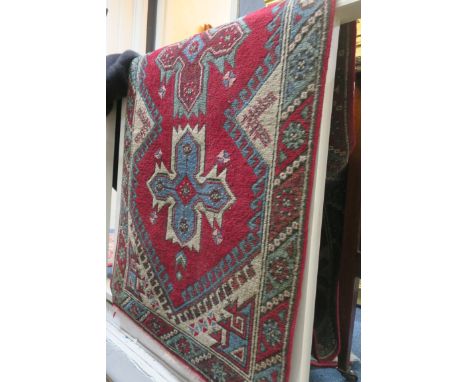 A SENNEH PERSIAN WOOL RUNNER the red and light blue ground with central serrated panels, palmets and hooks within a conformin