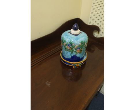 A GEORGE JONES STYLE GLAZED POTTERY COVER ON STAND, the light and dark blue ground moulded in relief with flowerheads and fol