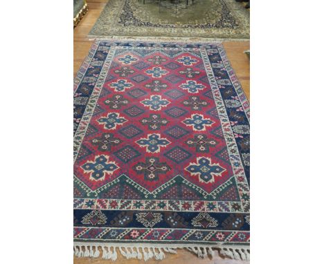 A DUSHBMALTI TURKISH HANDMADE WOOL RUG, the wine and light blue ground with central geometric panels within a conforming bord