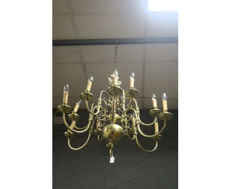A TWELVE LIGHT GILT BRASS CONTINENTAL STYLE CHANDELIER, hung in two registers, issuing scrolled arms with circular drip plate