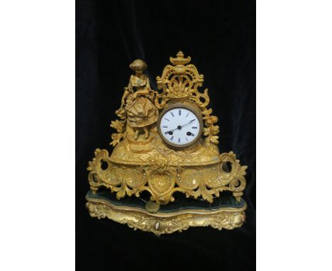 A FRENCH GILT METAL MANTEL CLOCK, the enamelled dial with Roman numerals, surmounted with a seated female raised on a pierced