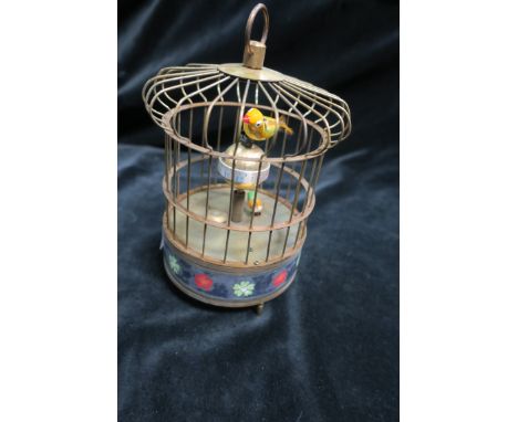 A BRASS CASED AUTOMATON MODELLED AS A CAGE, with two singing birds above a painted base on tubular supports.