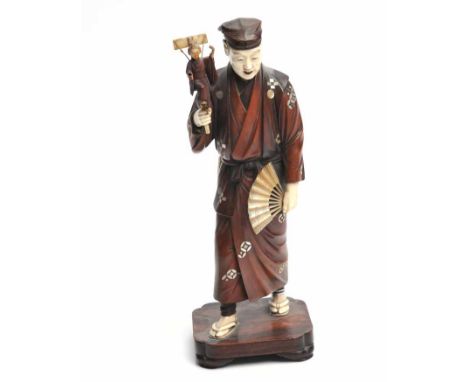 JAPANESE MEIJI PERIOD CARVED WOOD AND IVORY FIGURE OF A PRIEST
circa 1868-1912, the standing figure holding a fan carved of m