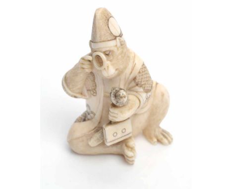 LATE 19TH/EARLY 20TH CENTURY JAPANESE IVORY NETSUKE
modelled in the form of a monkey, seated and holding a magnifying glass i