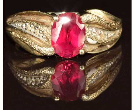 A 9ct gold ring set with an oval cut synthetic ruby and diamonds, 3.8g, size O