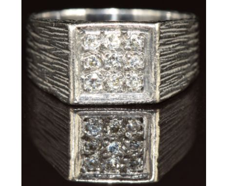 An 18ct white gold ring set with nine diamonds in a square setting, with textured shoulders, 6.2g, size J