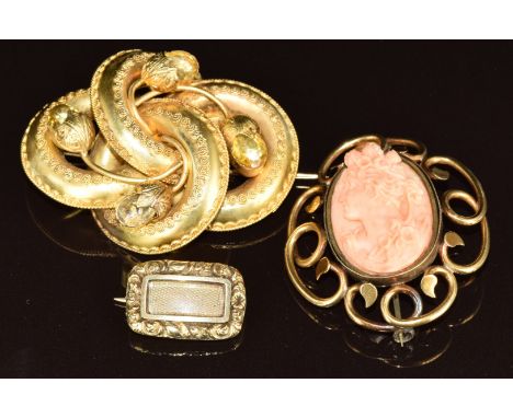 Three Victorian brooches comprising a knot set with foiled citrines (one missing, tests as 15ct gold, 13.9g, 5cm), a carved c