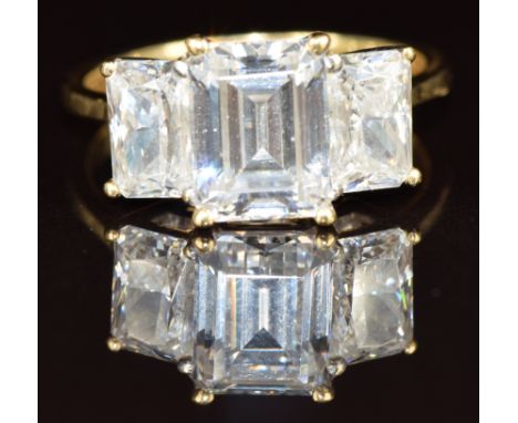 An 18ct gold ring set with three emerald cut cubic zirconia, 6.2g, size O