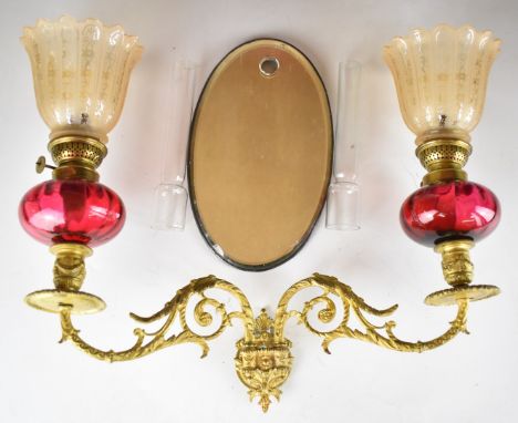 19thC gilt metal and cranberry glass wall sconce or lamp, with bevelled mirror back and twin arms, each supporting a glass re