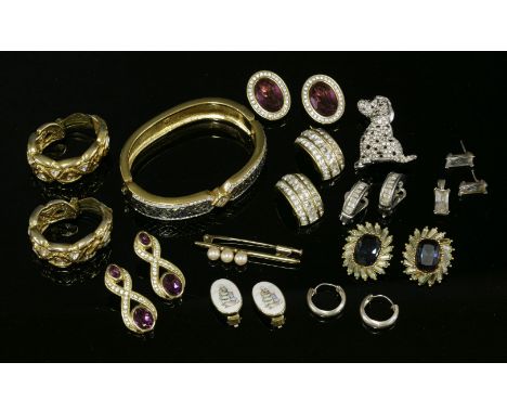 A Swarovski blue and white paste hinged bangle,a pair of Swarovski purple and white paste clip-on earrings,two pairs of Chris