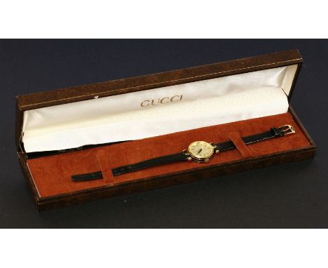 A ladies' gold-plated Gucci quartz 20000L watch, with a champagne dial, black Roman numerals and black second hands, black en