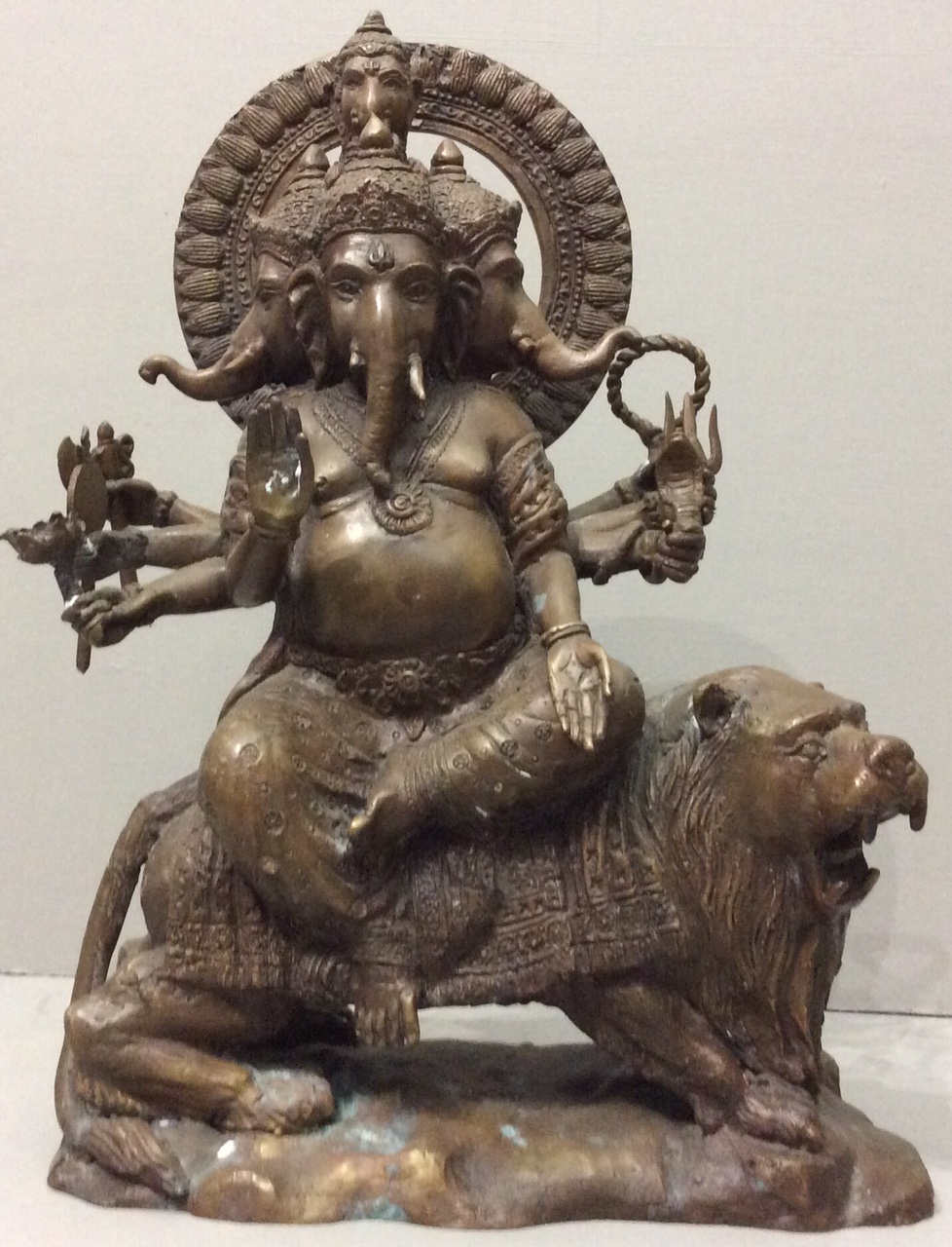 AN ANTIQUE INDIAN BRONZE STATUE OF GANESH AND LION Seated pose having ...