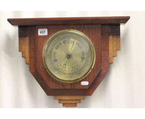 An Art Deco oak mounted hanging wall aneroid barometer