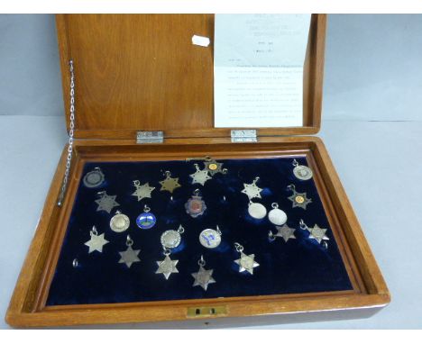 Various silver and enamel swimming and other sports badges encased in a mahogany box