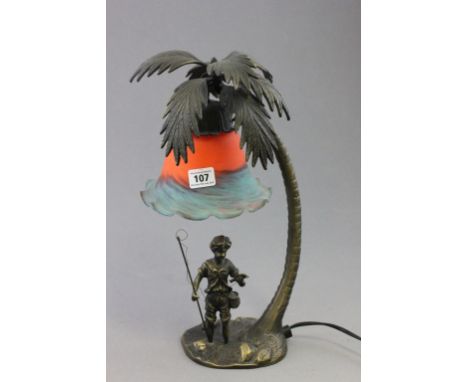 A novelty bronze lamp figure under a palm tree with Tiffany style shade
